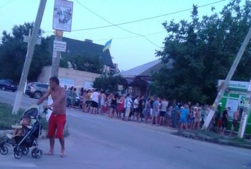 7 июля 2015 г. Железный Порт. Очередь к одному из немногих банкоматов (фото из соцсетей). На курорте, приносящем воротилам огромные прибыли, инфраструктура, мягко говоря, оставляет желать лучшего.. 