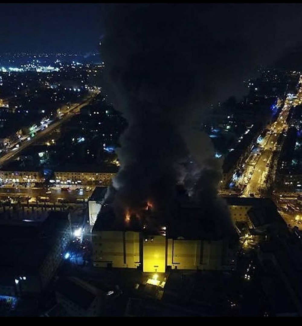 Даже спустя полдня после начала пожара наз зданием стоит столб дыма Фото: Александра Иноземцева