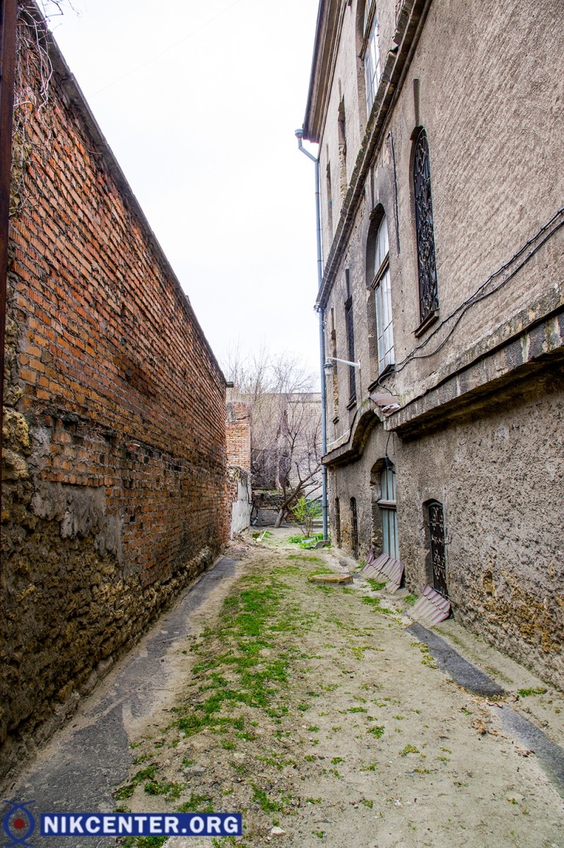 Слева - аварийная стена летней площадки и бывшего туалета. Тут планируется сделать подъезд для инвалидных колясок к будущему лифту. Между стеной и зданием находится теплотрасса, проложенная с нарушениями строительных норм: она должна находиться на расстоянии не менее 10 метров от здания музея.