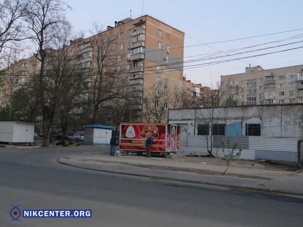 Рабочие обклеивают киоск